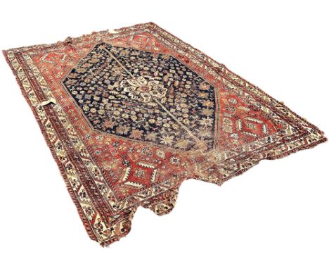 An old worn and torn Persian rug with a central panel interspersed with flowers, 230cm x 160, together with a smaller rug 135