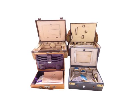 An Art Deco vanity travelling case with silver  hair brush, comb, hand mirror and silver capped bottles, two further vanity c