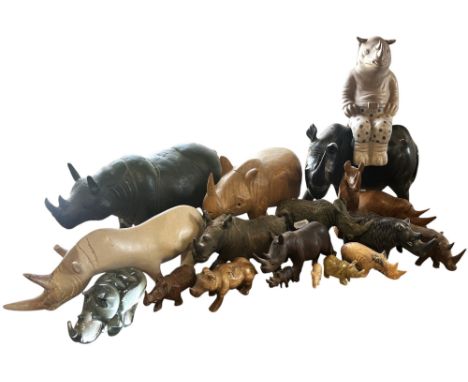 A collection of rhinoceros made from various materials, wood, marbles, metal ware, of varying sizes.