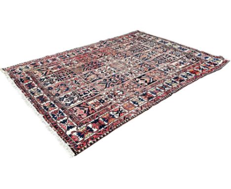 A Persian bakhtiar rug with red ground and an extended medallion to the centre, worn and repaired in places, 184cm x 126cm