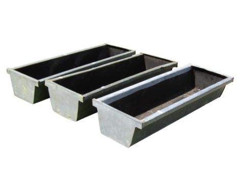 Three weathered galvanised planters of rectangular tapered form raised on wooden sledge feet, 19 cm high x 77 cm x 29 cm