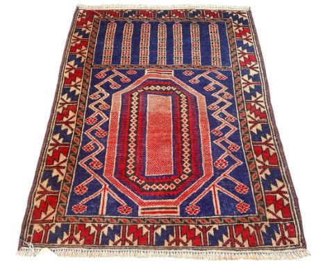An Eastern prayer rug decorated with stylised flowers within geometric boarders, 135cm x 90cm