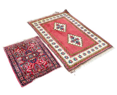 A Kazak type rug with two step medallions in geometric boarders, 101cm x 145cm, together with a smaller Persian style mat, 78