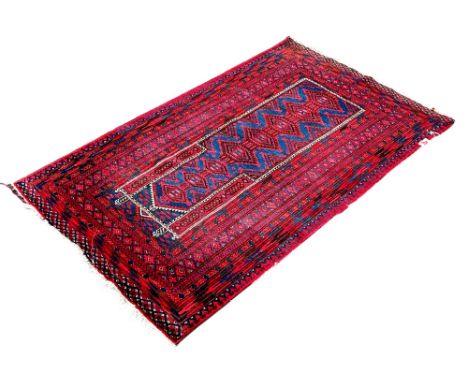 A Middle Eastern prayer rug with central panel with interconnecting medallions in tones of red and blue, 150 x 90 cm