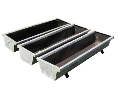 Three weathered galvanised planters of rectangular tapered form raised on wooden sledge feet, 18 cm high x 88 cm x 29 cm