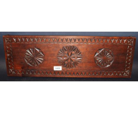 A carved mahogany folk art plinth, decorated with 3 roundels, arrowhead border, 61 cm x 20 cm