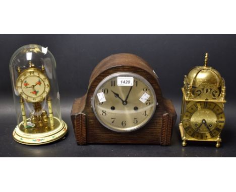 A brass lantern clock; German torsion clock, glass dome; Oak mantle clock (3)