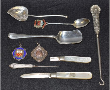 A silver fruit knife, mother of pearl handle; another; a silver hafted button hook; a silver cricket medal, 1928; another 192