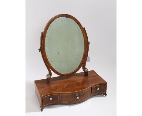 Regency mahogany and boxwood strung toilet mirror, the oval mirror plate above a serpentine base with three short drawers and