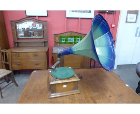 An oak table top gramophone with metal horn speaker