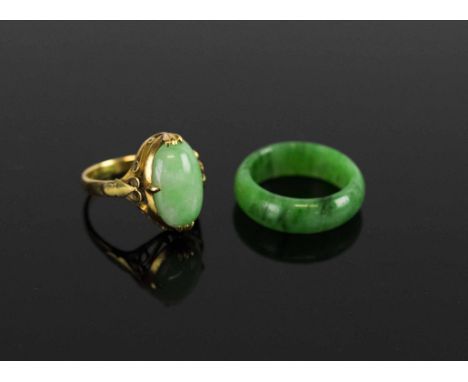 A FINE JADETTE BAND RING, of bright mottled apple green coloured jade, finger size L½, and a yellow gold and cabouchon jadett