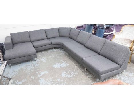 CORNER SOFA, in a grey fabric in six sections on metal supports 317cm x 260cm, original cost over £4000.