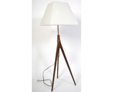 A retro 20th century teak wood Danish inspired standard floor lamp of tripod atomic form with beige shade atop. Measures 135c