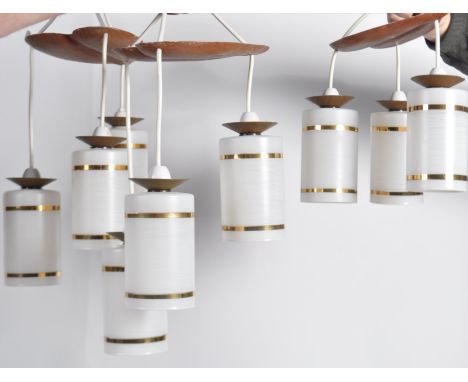 A set of three triple drop ceiling lights.  These vintage lamps have opaque glass shades hanging at various heights with gold