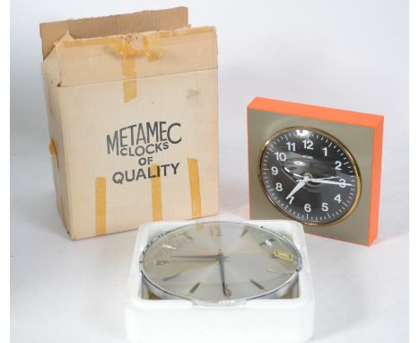 A superb vintage Metamec  mains powered wall clock with black face, white numerals and hands and framed in vibrant orange alo