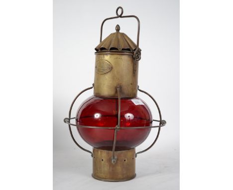 An early 20th century  nautical brass ships onion shaped lantern. Having red glass onion shade, hanging handle atop with make