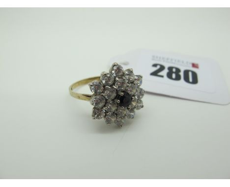 A Large 9ct Gold Cluster Ring, of flowerhead design, claw set throughout, between tapered shoulders (finger size R) (4grams).