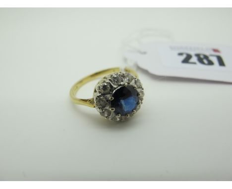 An 18ct Gold Sapphire and Diamond Circular Cluster Ring, claw set within border of brilliant cut stones (finger size M) (3.2g