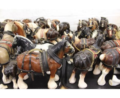 A large quantity (approximately 38) of ceramic  shire horse ornaments, most in full tack, along with three drays and a furthe