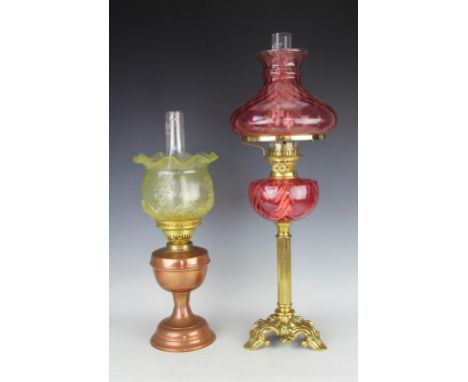 An Art Nouveau oil lamp, the cranberry glass reservoir and shade on moulded base, 68cm high, along with a smaller oil lamp wi