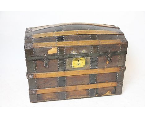 A late 19th century dome top bentwood and metal bound trunk, the leather covered trunk with stamped detailing and embossed de