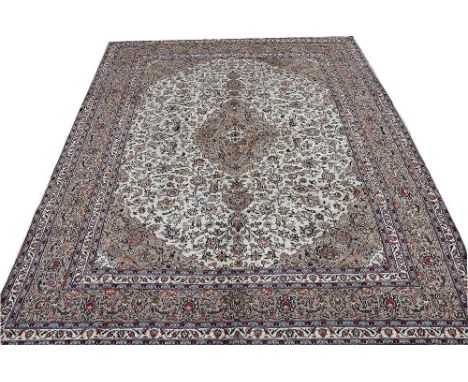 A large Persian Meshad wool carpet, worked with a central medallion and all over foliate design against an ivory ground, 370c