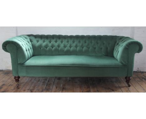 A Victorian button back Chesterfield settee, with green drailon upholstery, on turned legs and fitted casters, 70cm H x 204cm