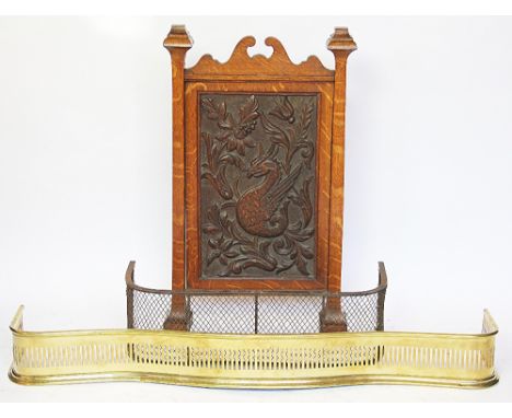 A late Victorian carved oak fire screen, decorated with a griffin, 83cm H x 49cm W, with a serpentine brass fire curb and a s
