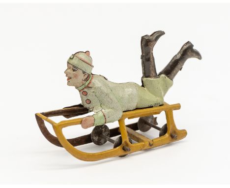 Meier: An early 20th century, lithographed tinplate penny toy young boy on sled. Made in Germany, by Meier. Stamped to unders