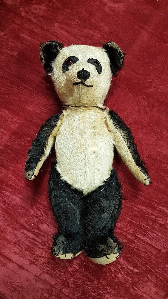 A 1940s vintage panda bear straw filled and with humped back plus a