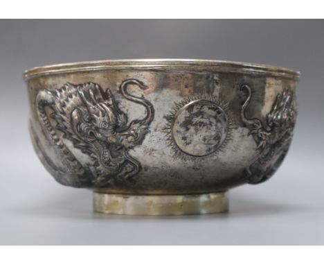 A late 19th/early 20th century Chinese Export white metal bowl, embossed with two dragons chasing a pearl, engraved with a 19