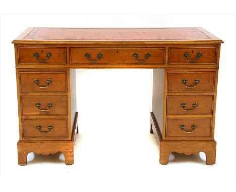 A yew wood pedestal desk, the moulded rectangular top, with tooled inset red leather skiver, over three frieze drawers, each 