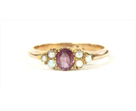A gold garnet and split pearl ring, with an oval mixed cut garnet with a trefoil of split pearls at each side, all claw set t