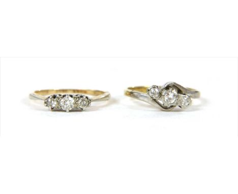 An 18ct gold three stone diamond ring, with three Swiss cut diamonds, grain set to crossover shoulders and a plain shank, Lon