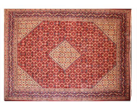 A Persian karajeh carpet , 20th century, with repeating geometric motifs on a red ground, 401 x 295cm