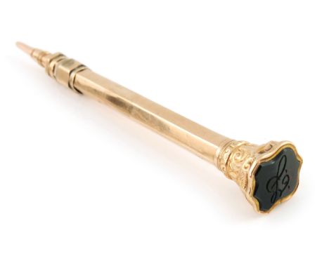 A 9 carat gold seal topped retractable propelling pencil, hexagonal section barrel, the foliate capital terminal set with a s