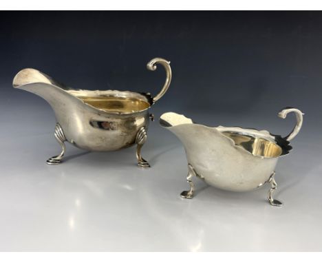 An Edwardian and George V silver sauce boat, London 1908 and Sheffield 1916, both of helmet form with ogee rims, on stepped p