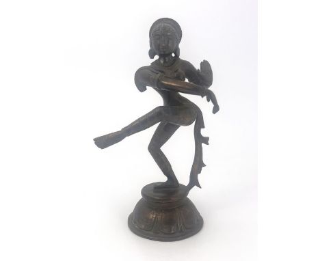 A cast bronze figure of an Indian Hindu goddess Shira, modelled dancing, on cast circular base with moulded lappet and tassel
