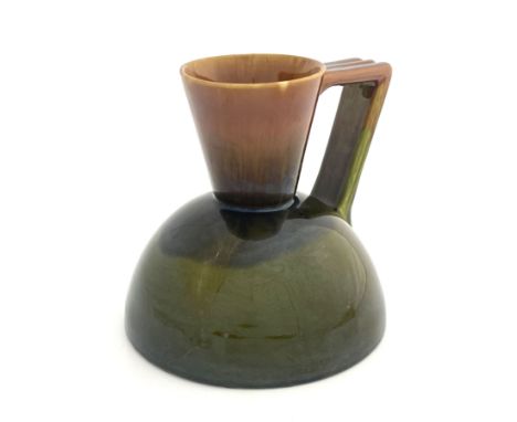 Christopher Dresser for Linthorpe, an art pottery jug, circa 1880, the hemispherical body with conical neck and angled strap 