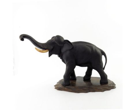 A Japanese bronze elephant by Genruysai Seiya, Meiji period, 1868-1912, modelled strolling with trunk up, ivory tusks, (s.d) 