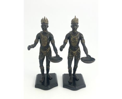 A pair of bronze Nubian warrior figures, modelled wearing crowns and holding trays, highlighted in gilt, 37cm high (2)