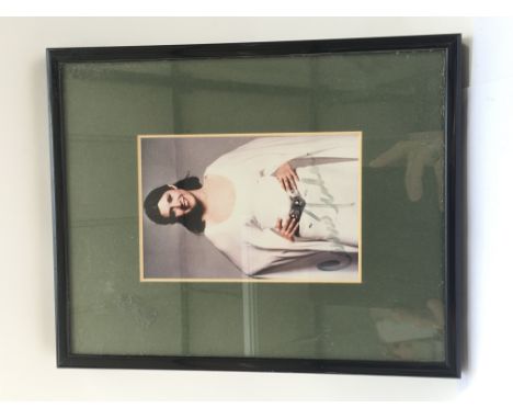 A framed and glazed signed colour print of Carrie Fisher as Princess Leia, approx 21cm x 26cm. Signature slightly faded.