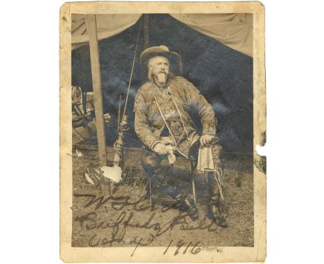 CODY W. F.: (1846-1917) American Showman. Vintage signed and inscribed sepia 4 x 5 photograph of Cody seated outdoors in a fu