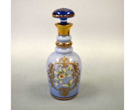 AN OPAQUE BLUE GLASS DECANTER AND STOPPER, with relief moulded floral decoration to hand painted leaves and gilt decoration, 