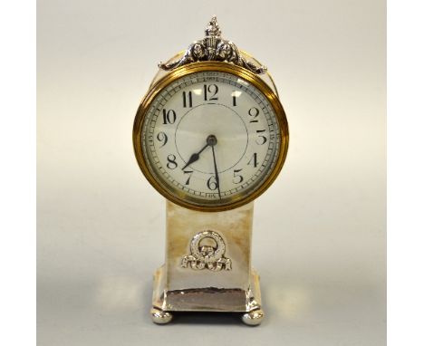 A SILVER MANTEL CLOCK, drum shape case with scroll and flame finial and beaten square plinth support with relief wreath on fo