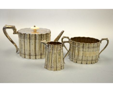 A SILVER VICTORIAN THREE PIECE TEA SERVICE, of reeded form with punched and beaded strapwork, London 1879, Thomas Bradbury & 