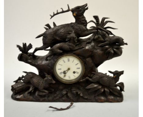 A 19TH CENTURY BLACK FOREST MANTEL CLOCK, carved with stag being hunted by hounds over barrel movement and hinds amongst fern