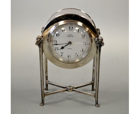 AN ARTS & CRAFTS SILVER PLATED MANTEL CLOCK, c.1905, with circular barrel movement case on four tapering ribbed supports and 