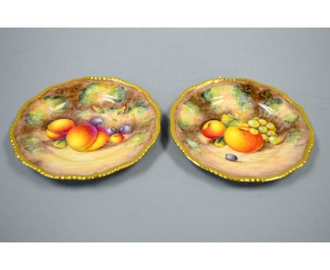 TWO ROYAL WORCESTER HAND PAINTED FRUIT PLATES, apples, grapes, peaches and cherries before mossy bank, both with gilt borders