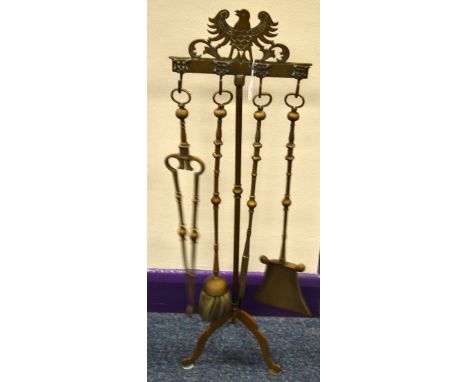 A TRIPOD COMPANION SET, with open winged bird to top rail over four hooks with tongs, brush, poker and shovel, approximately 